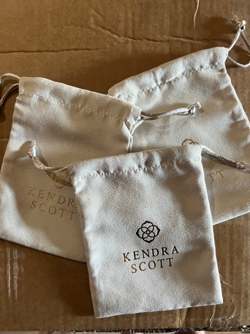 Kendra Scott Soft Drawstring Jewelry Pouches in Light Cream with Gold Logo